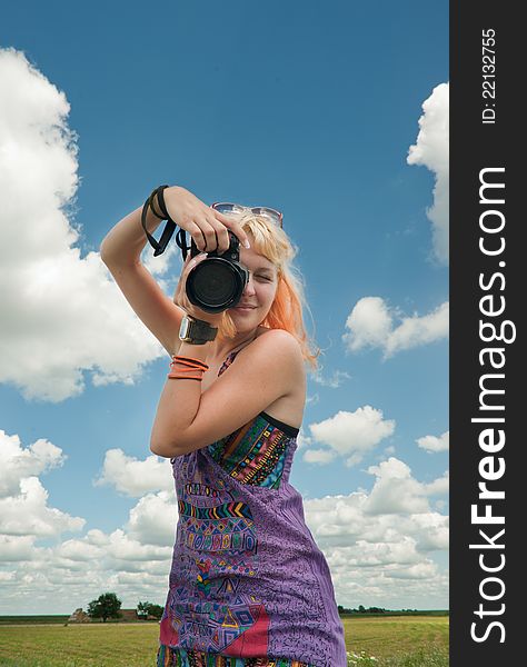 Blond-haired woman taking a photo with a camera. Blond-haired woman taking a photo with a camera