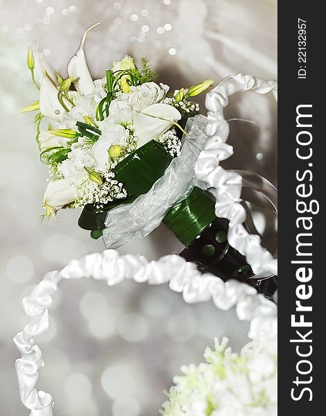 A white arum lily bouquet on sparkly, festive background. A white arum lily bouquet on sparkly, festive background.