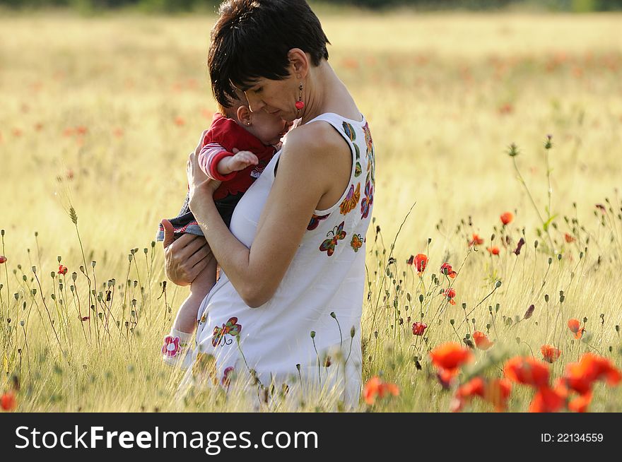 A mother with her daughter in a poppy field in Granada, Andalusia, Spain. A mother with her daughter in a poppy field in Granada, Andalusia, Spain