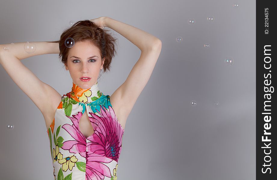 Fun portrait of attractive woman in colorful dress surrounded by bubbles. Fun portrait of attractive woman in colorful dress surrounded by bubbles