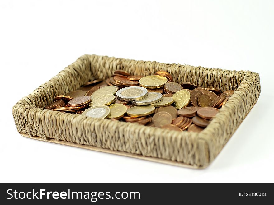 A lot of coins loose in a basket. A lot of coins loose in a basket