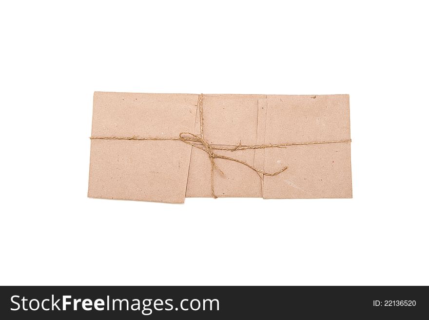 Isolated small parcel wrapped in brown paper with rough rope knot. Isolated small parcel wrapped in brown paper with rough rope knot