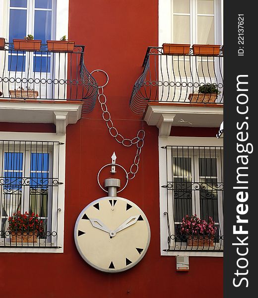 Watchmaker's shop sign on red painted facade. Watchmaker's shop sign on red painted facade.