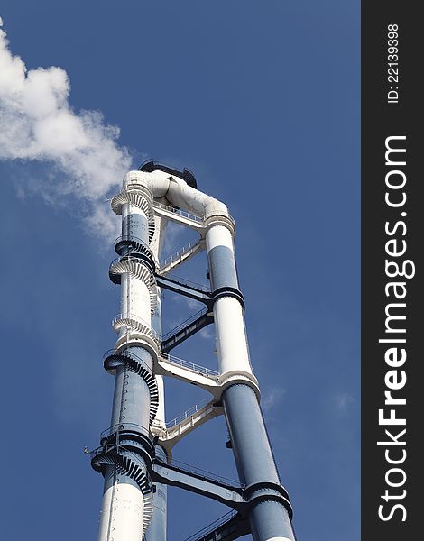 Smokestack with white smoke clear blue sky