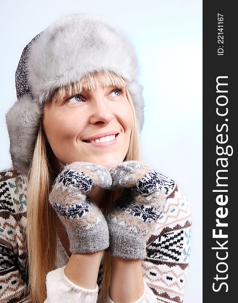 Beautiful young smiling woman in a knitted sweater and fur hat. Beautiful young smiling woman in a knitted sweater and fur hat