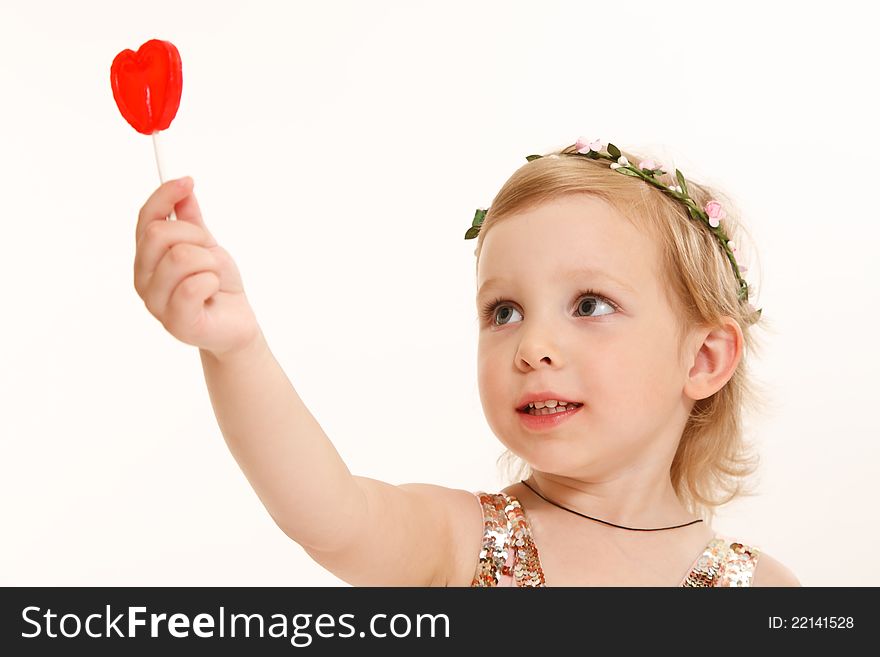 Portrait of a young girl with a sweet heart in hand. Portrait of a young girl with a sweet heart in hand