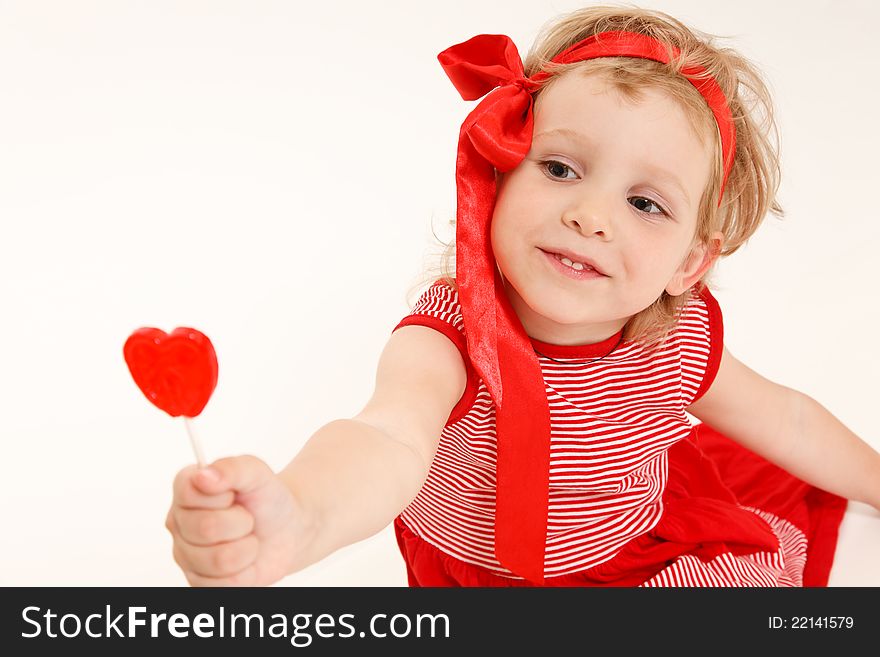 Little girl in a red dress with sweet heart. Little girl in a red dress with sweet heart.