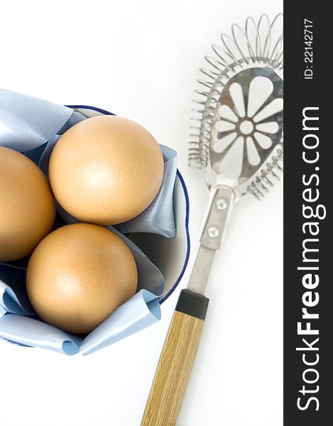 Eggs with kitchenware on white background