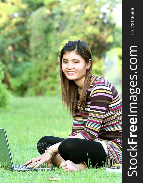 Asian female college student studying with a laptop computer. Asian female college student studying with a laptop computer