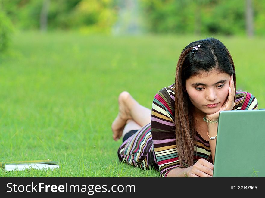 Asian female college student studying with a laptop computer. Asian female college student studying with a laptop computer