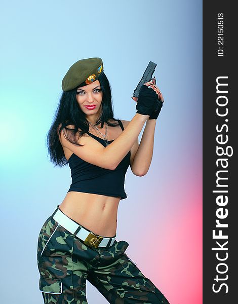 Attractive girl with hand gun. military style wear