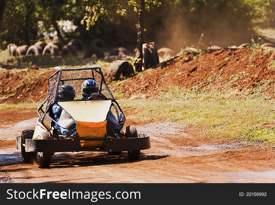 Two people driving a buggy on the track in the park