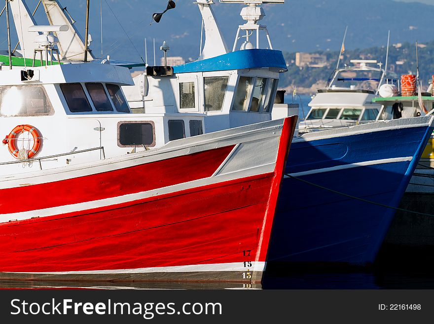 Red and blue fishing boats in the harbor