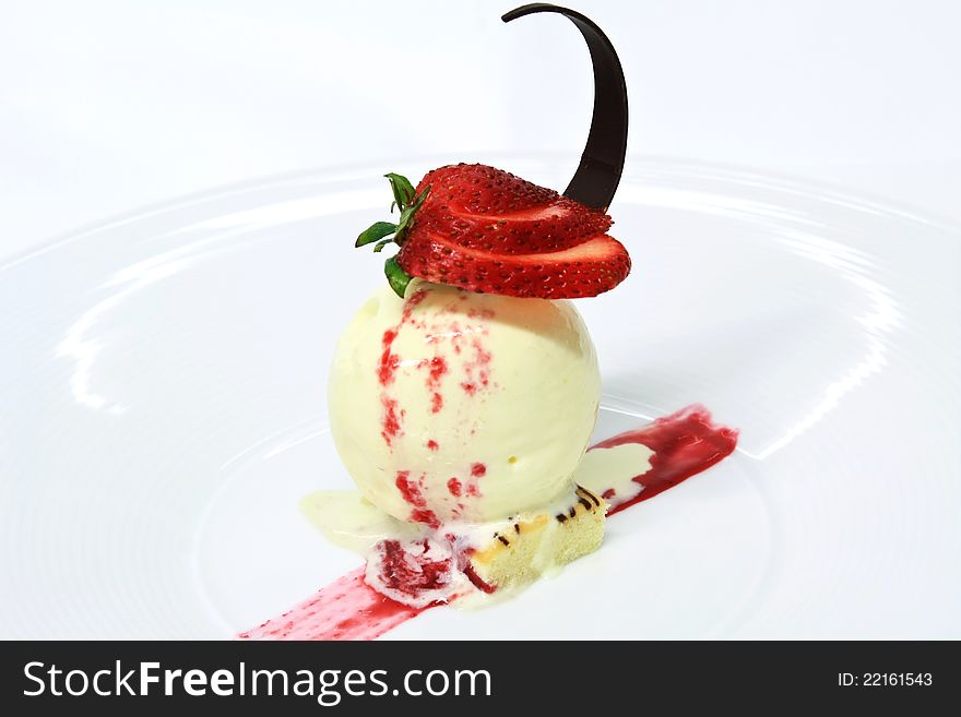 Vanilla ice cream topped with strawberry jam decorated with fresh strawberries