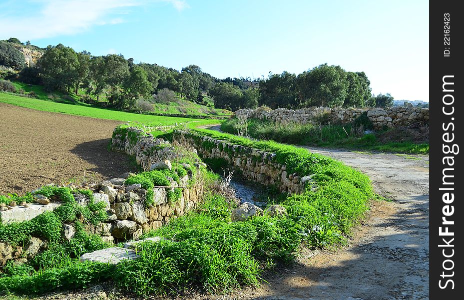 A winding road along a water stream in the Maltese countryside. A winding road along a water stream in the Maltese countryside