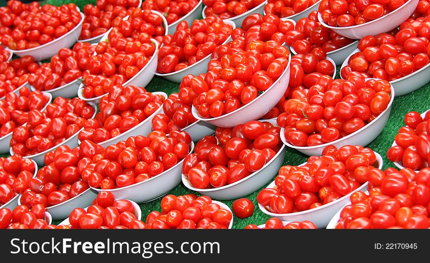 A Display of Small Red Plum Tomatoes in White Bowls. A Display of Small Red Plum Tomatoes in White Bowls.