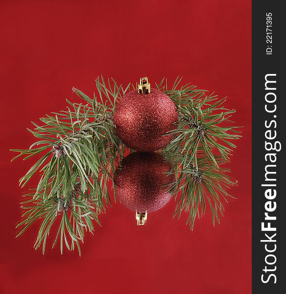 Christmas decoration. Pine branch, red ball. Mirror image