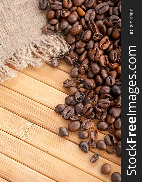 Coffee beans on wooden background with linen canvas