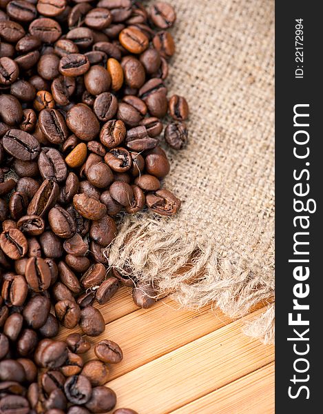Coffee beans on wooden background with linen canvas