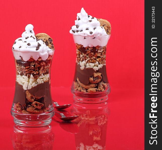 Two chocolate whipped cream desserts in a glass