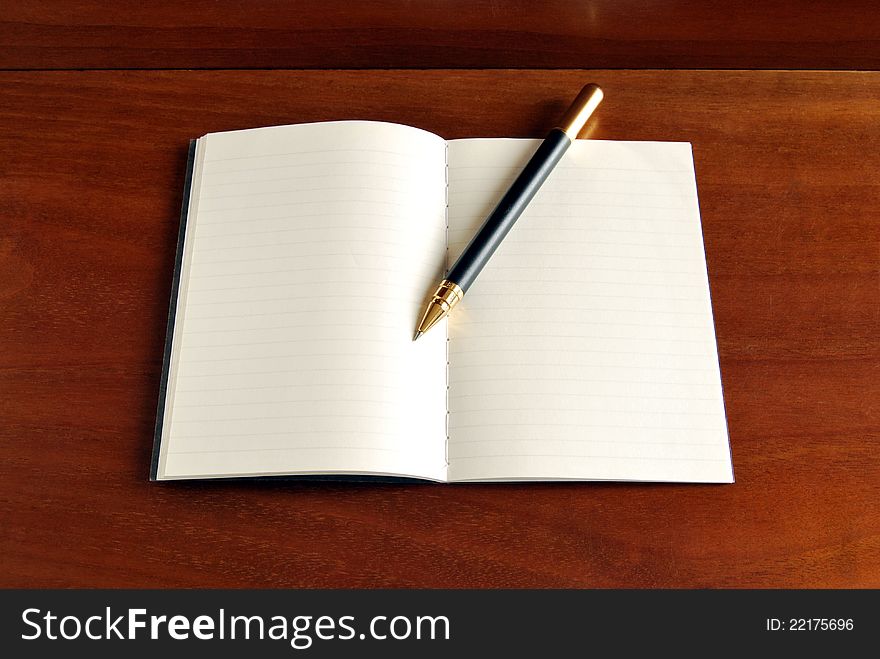 Notebook blank page on warm wood background. Notebook blank page on warm wood background