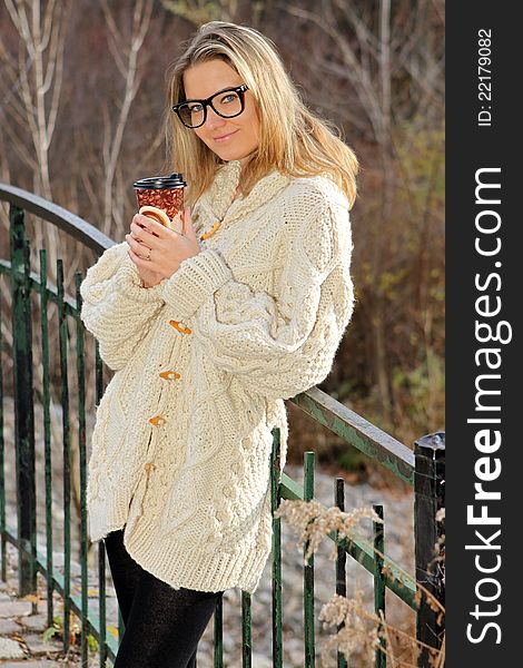 Beautiful woman enjoying her coffee outside on a nice fall day. Beautiful woman enjoying her coffee outside on a nice fall day