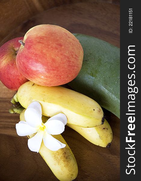 Tropical mixed fruits banana,mango and apple on wooden tray