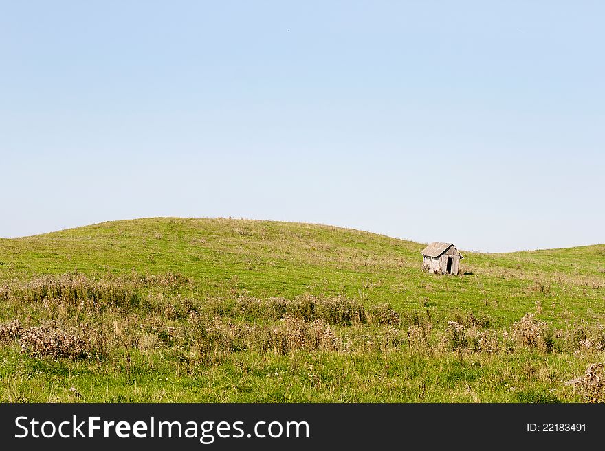Small wooden house. Wooden structure in the middle of the field. Small wooden house. Wooden structure in the middle of the field