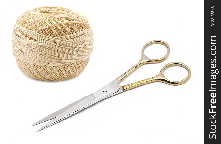 Thread and scissors on white background