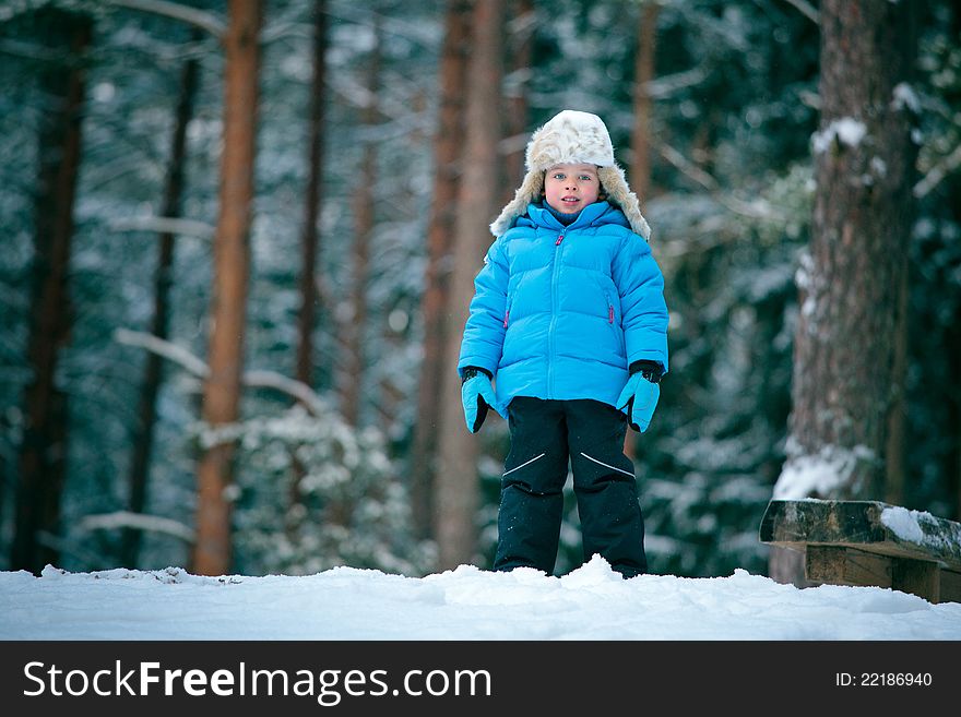 Portrait of a little boy playing outdoors in a winter forest