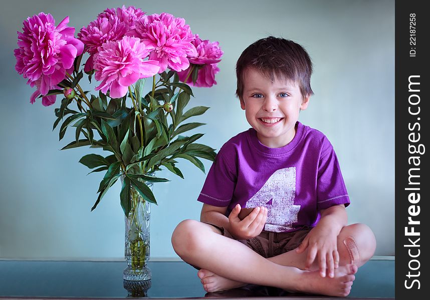Portrait of a cute boy with peonies