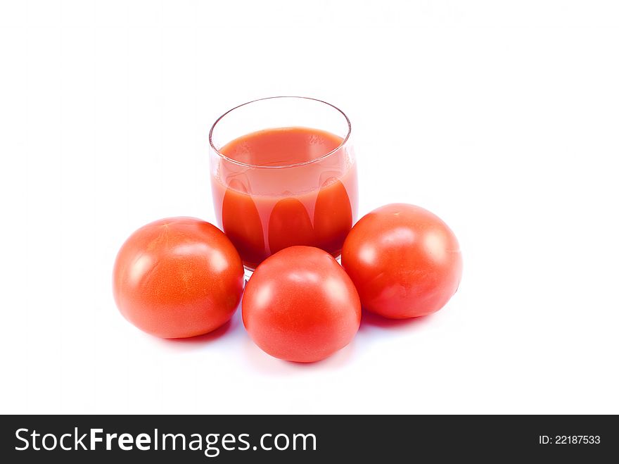 Tomatoes and a glass of tomato juice on white background