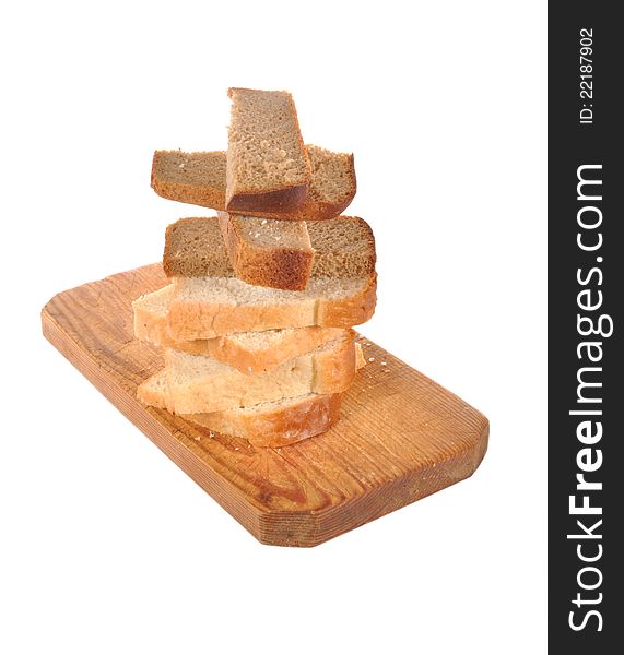 Pieces of bread lay on a wooden board