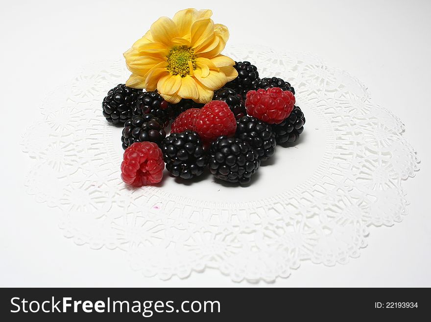 Raspberries blackberries and a flower arrange in a decorative manner. Raspberries blackberries and a flower arrange in a decorative manner