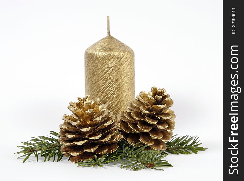 Gold candle with the twig of the spruce and cones. Gold candle with the twig of the spruce and cones