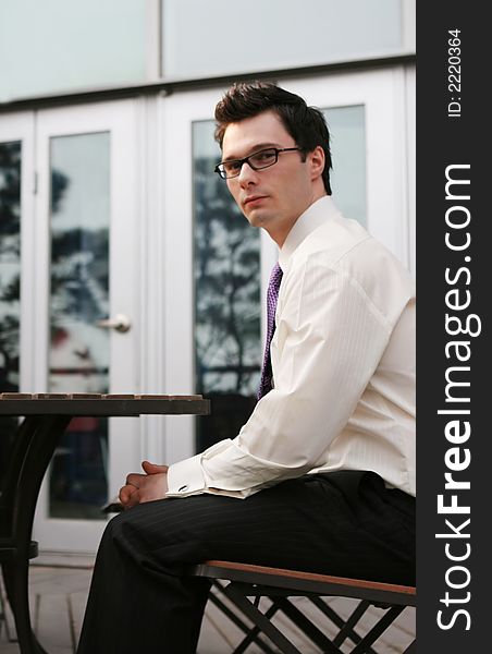 Attractive businessman sitting outside at a table