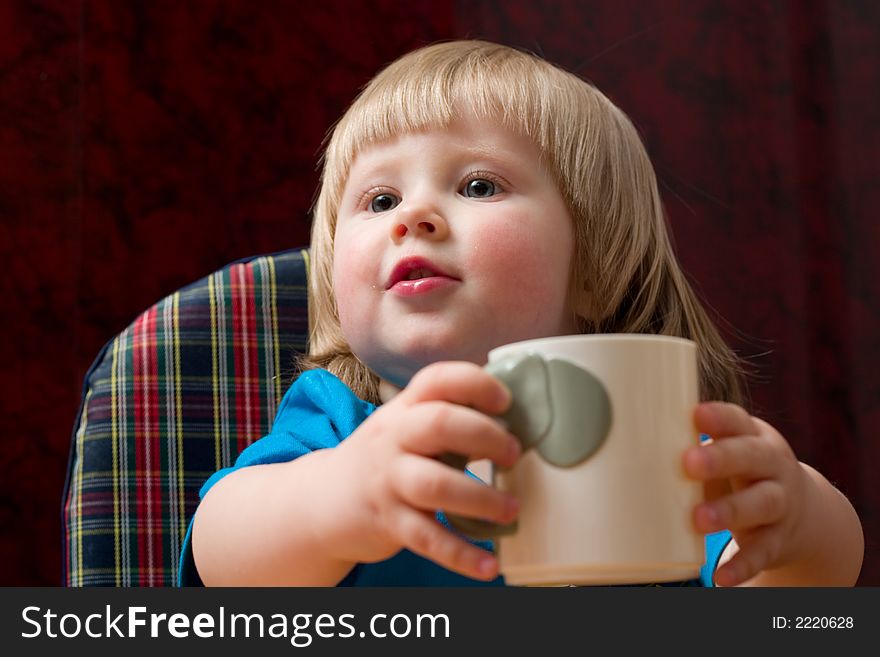 Cute little blond girl with cup in her hands. Cute little blond girl with cup in her hands