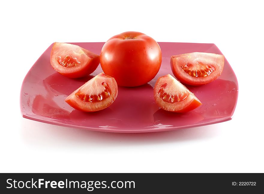 Photo of isolated fresh red tomatoes on a plate.