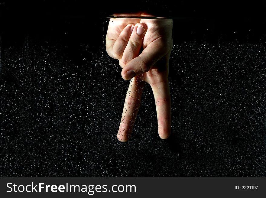 Photo of hand in the water on a black background.