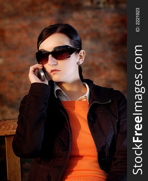 Photo of pretty female in sunshine light with cell phone. Photo of pretty female in sunshine light with cell phone.