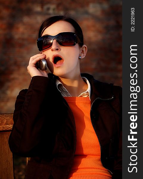 Photo of pretty female in sunshine light with cell phone. Photo of pretty female in sunshine light with cell phone.