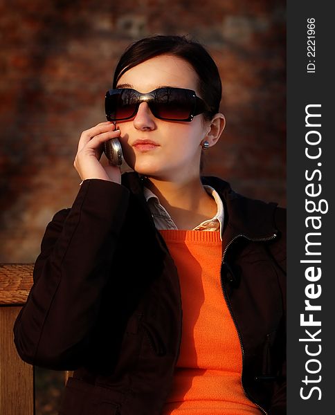 Photo of pretty female in sunshine light with cell phone. Photo of pretty female in sunshine light with cell phone.