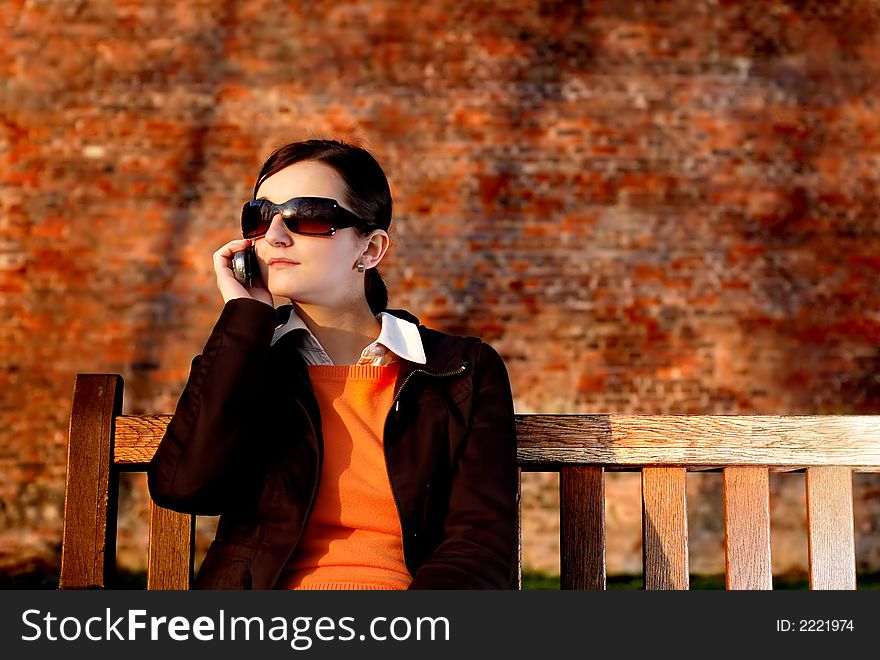 Photo of pretty female in sunshine light with cell phone. Photo of pretty female in sunshine light with cell phone.