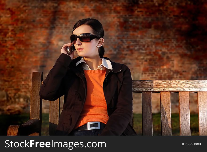 Photo of pretty female in sunshine light with cell phone. Photo of pretty female in sunshine light with cell phone.