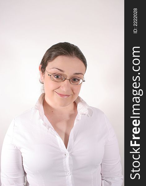 A young woman with glasses wearing a white button-down smiling at the camera. A young woman with glasses wearing a white button-down smiling at the camera