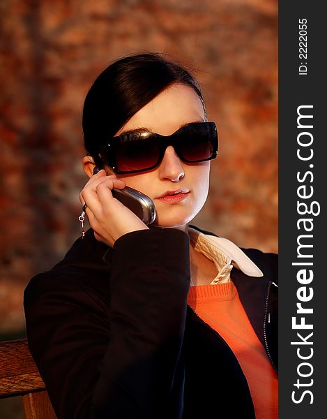 Photo of pretty female in sunshine light with cell phone. Photo of pretty female in sunshine light with cell phone.