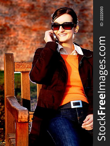 Photo of pretty female in sunshine light with cell phone. Photo of pretty female in sunshine light with cell phone.