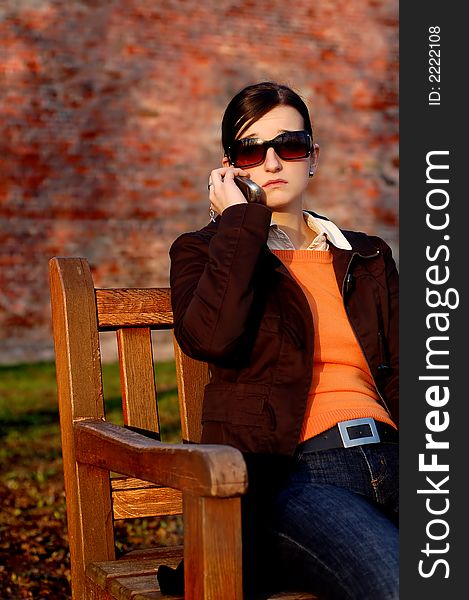 Photo of pretty female in sunshine light with cell phone. Photo of pretty female in sunshine light with cell phone.