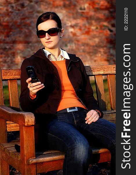 Photo of pretty female in sunshine light with cell phone. Photo of pretty female in sunshine light with cell phone.