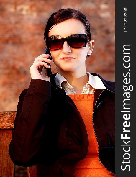 Photo of pretty female in sunshine light with cell phone. Photo of pretty female in sunshine light with cell phone.